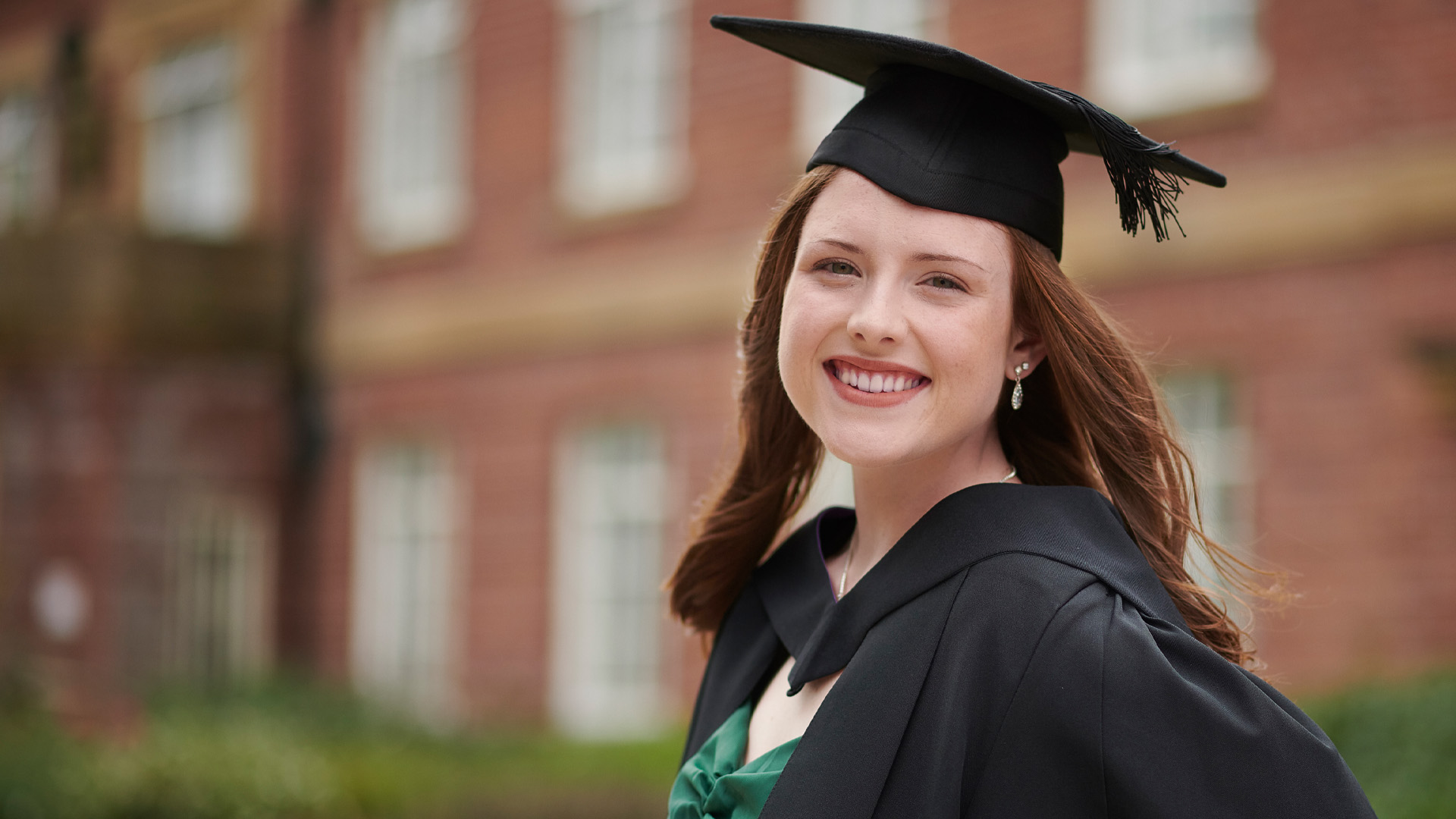 Rachel Brodie wearing a graduation cap and smiling.