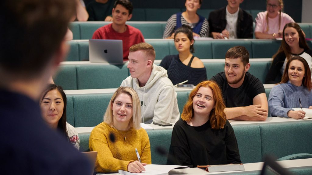   A group of students are attending a lecture in a lecture theatre. 