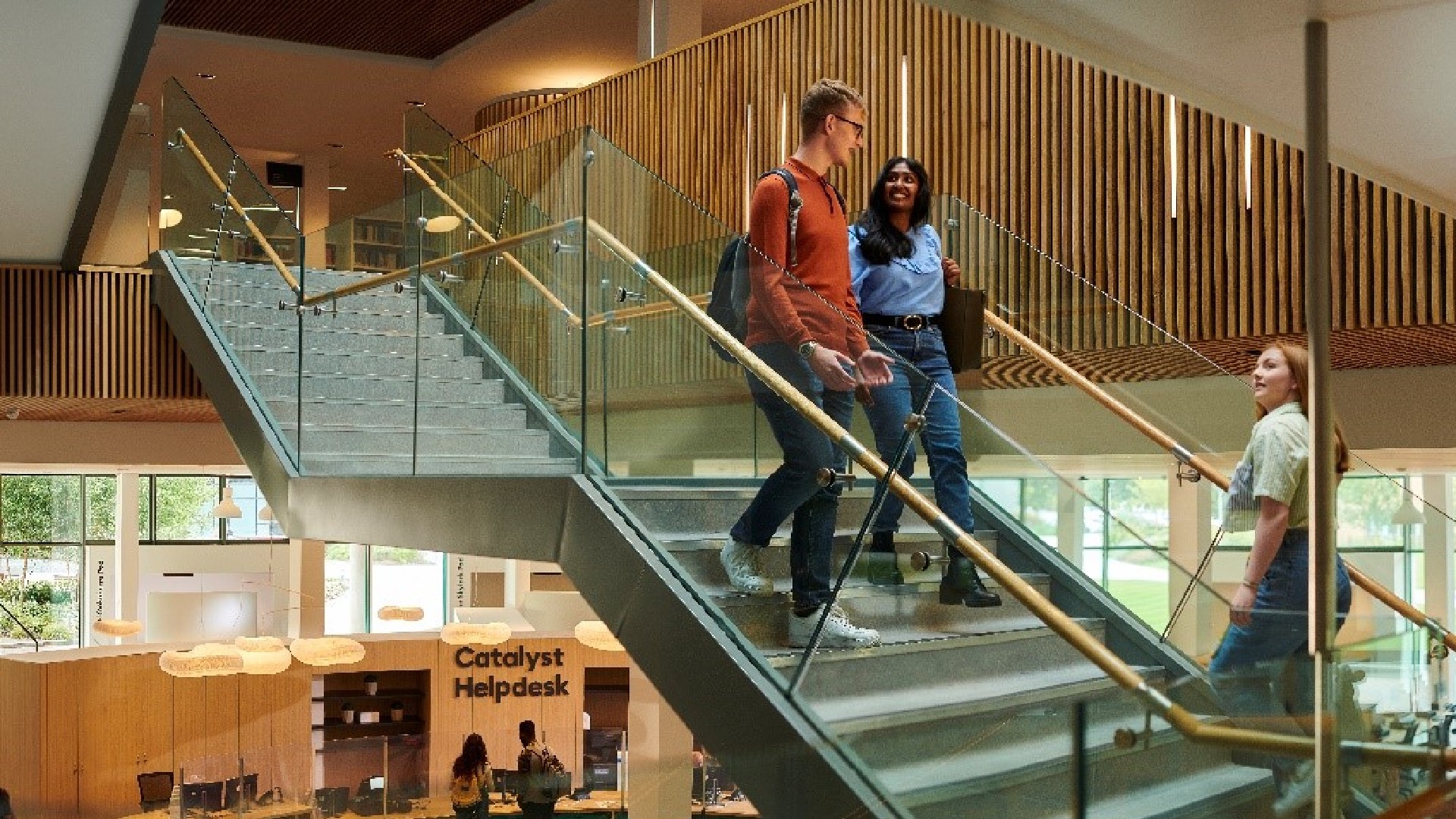 Students are walking down the stairs in the Universities Catalyst building.