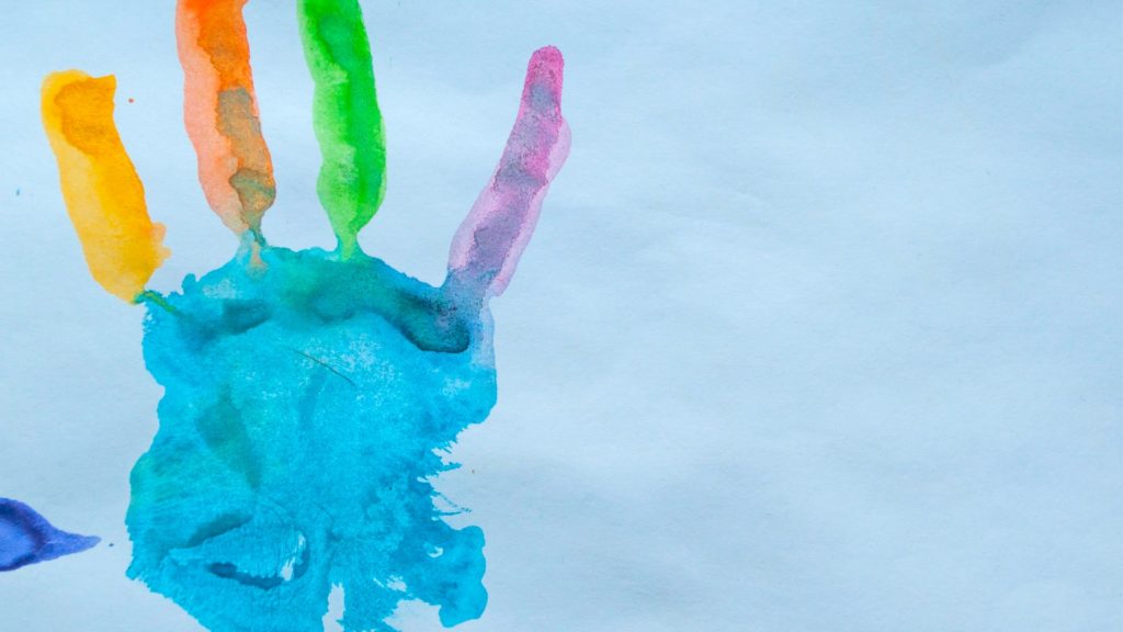  An image of a painted multi-coloured handprint. 