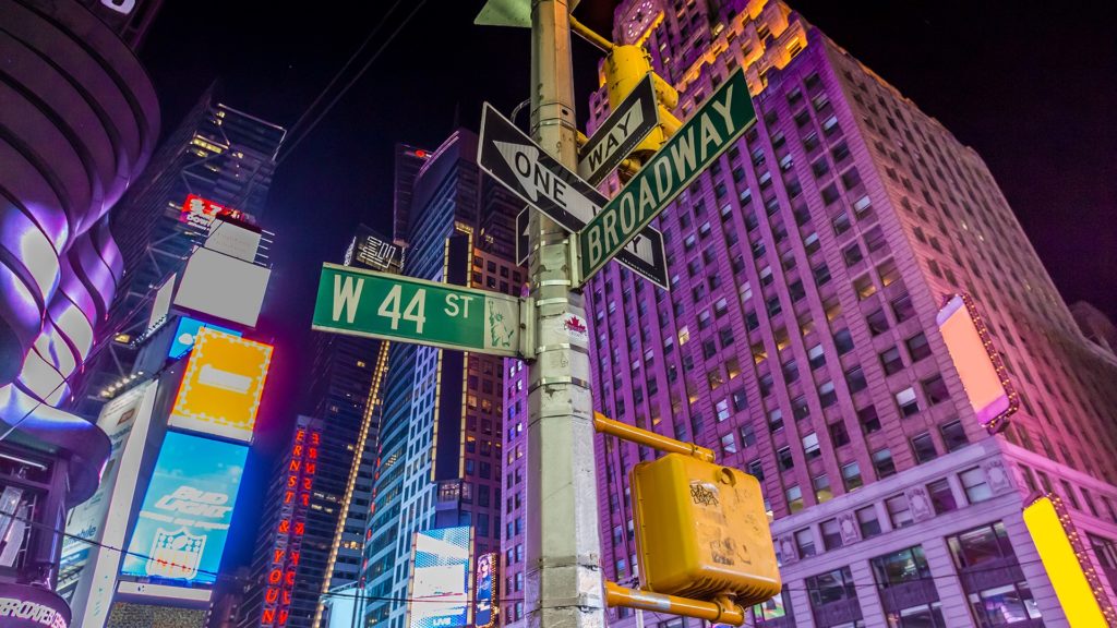 An image of a street sign in New York City, there are signs pointing to broadway and west 44th street.
