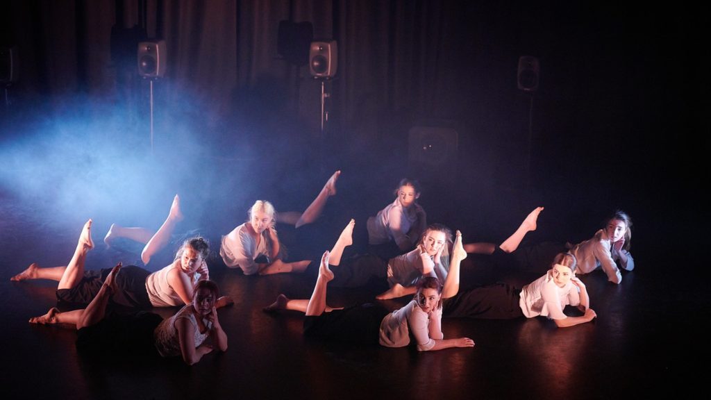  An image of performing arts students performing on a stage.