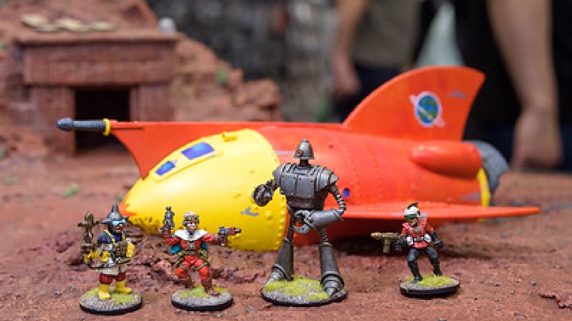 An image of four figures stood in front of a model spaceship.