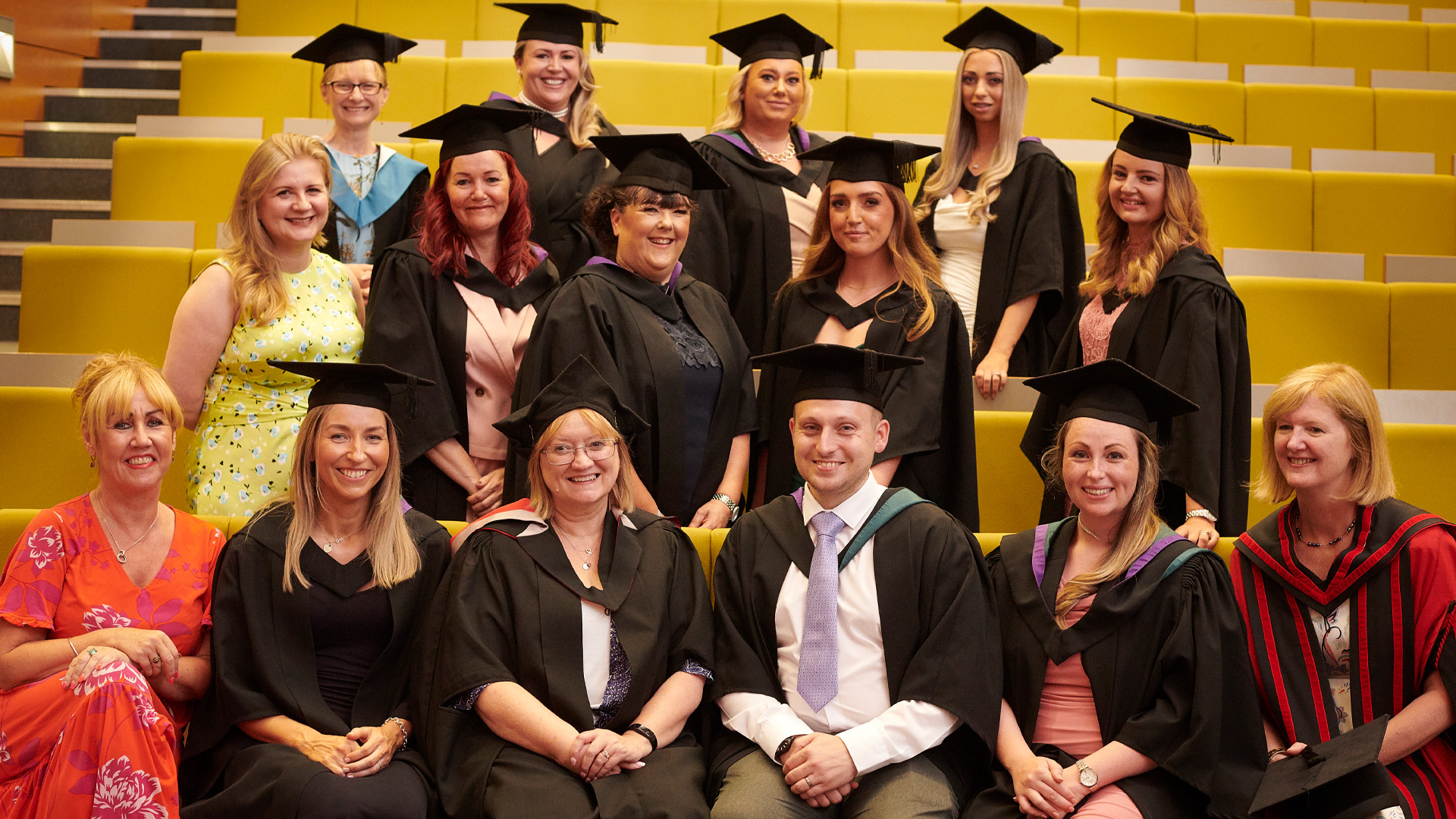 A nurse cohort wearing caps and gowns at graduation.