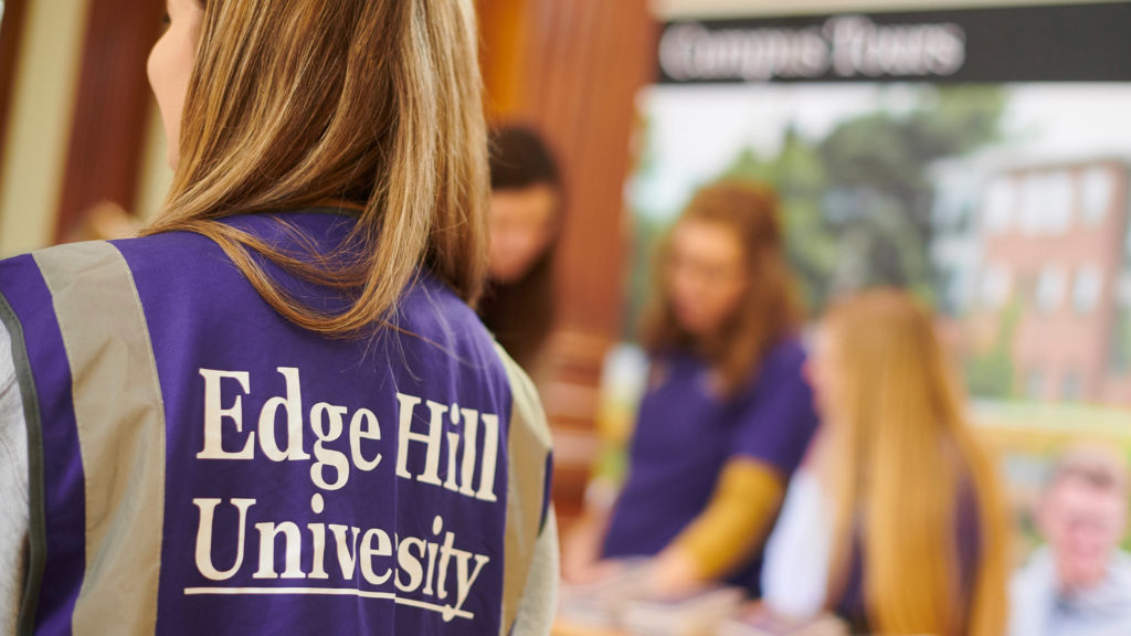 The back of a student wearing a purple jacket with Edge Hill University on