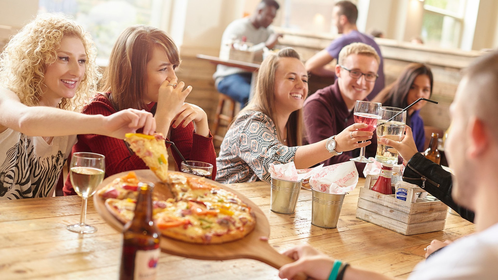 Students drink and share pizza