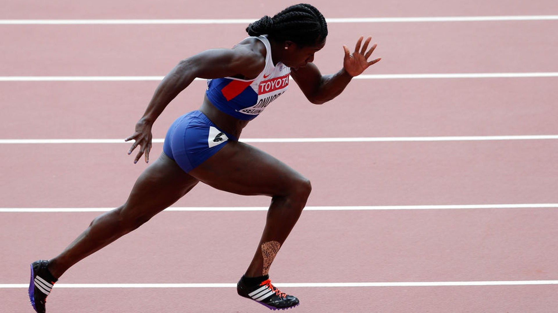 Olympian Anyika Onuora running on an athletics track