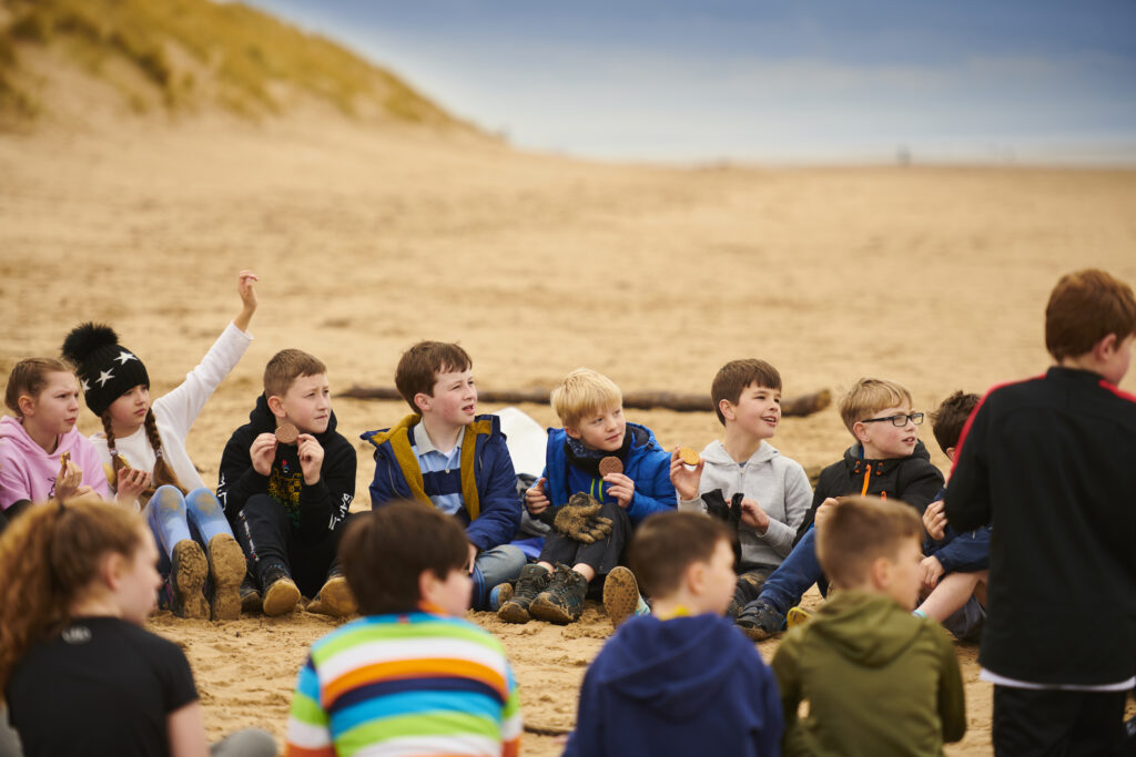 A picture of a group of children taking part in the beach school.