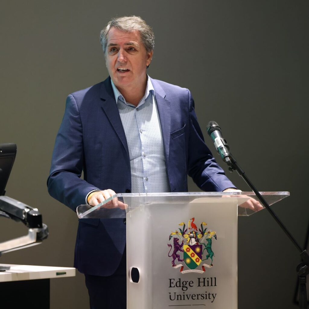 A picture of Mayor Steve Rotheram stood in front of an Edge Hill branded lectern. 