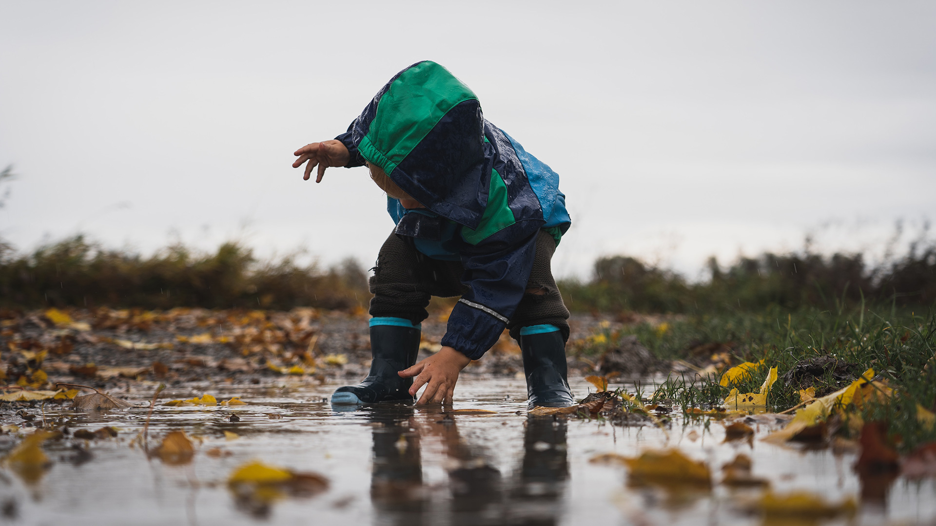 Child playing outside in the rain.