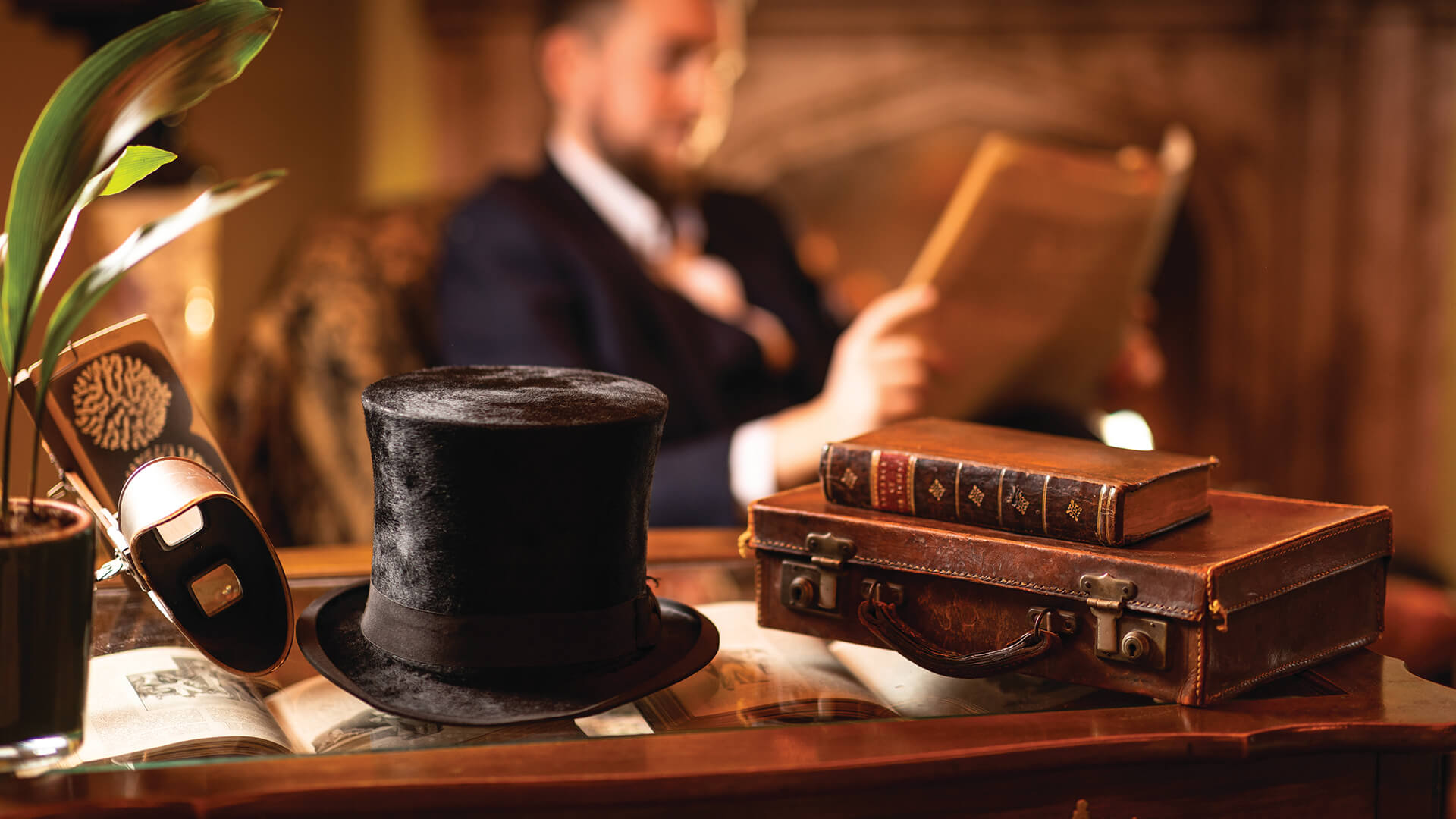 A top hat and brief case on a table