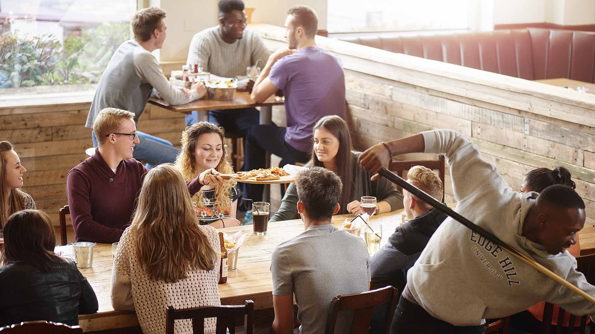 Students socialising together while sat around a table in the SU Bar.
