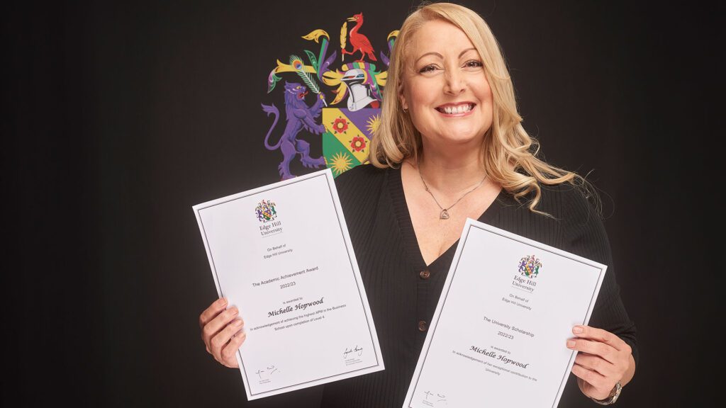 Business and Management student Michelle Hopwood holding two certificates - one is for The University Scholarship award, the other is for the Academic Achievement Award.