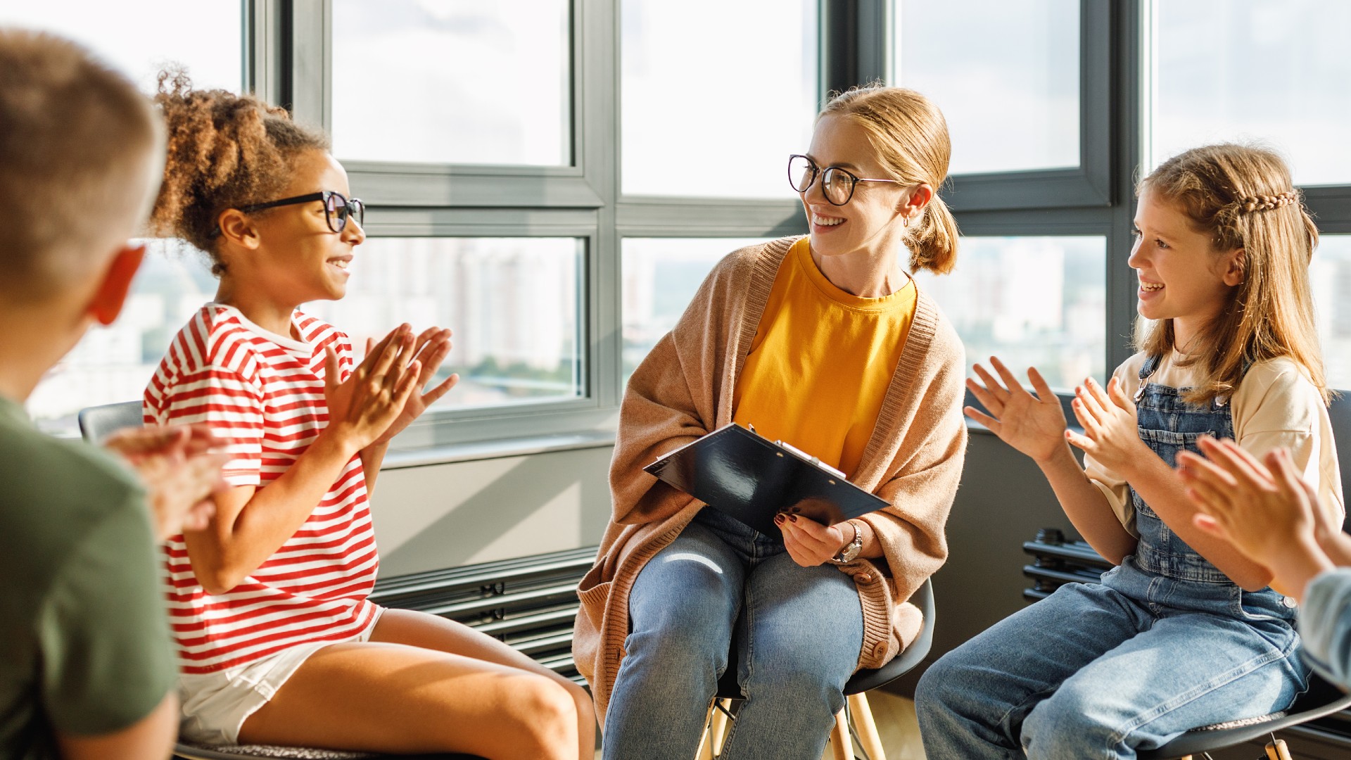 Three young people and a counsellor sit in a group talking.