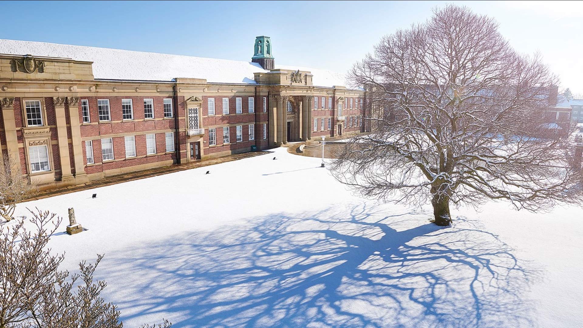 An ariel shot shows the entrance to the Main Building covered in snow.