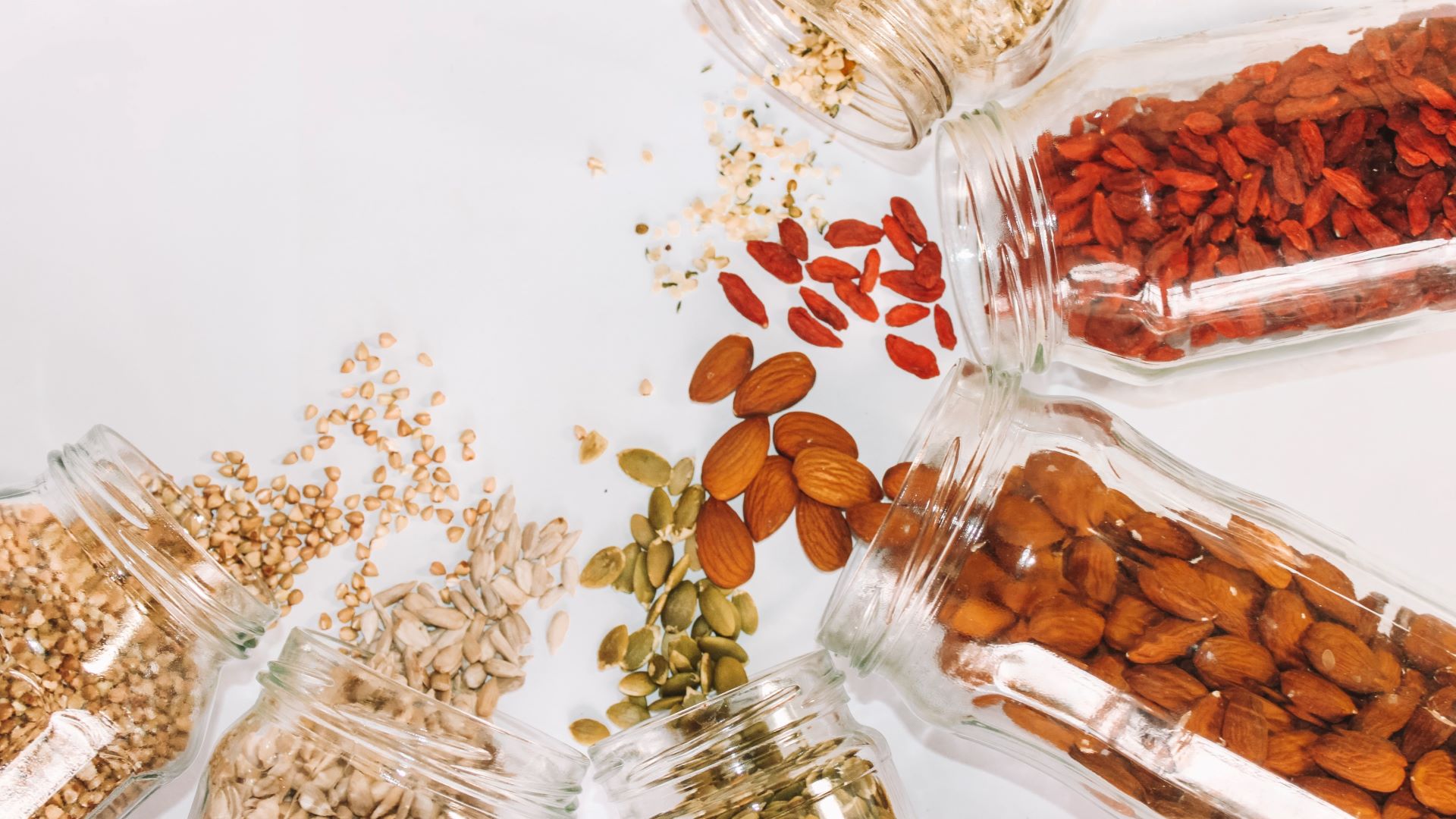 A picture of nuts and seeds spilling out of jars.