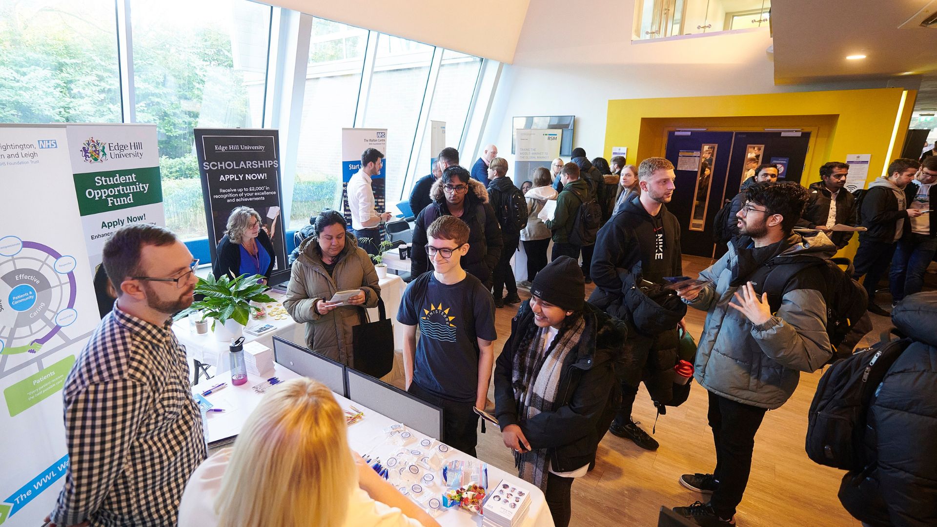 group of students and exhibitors at a busy computer science careers fair in the tech hub