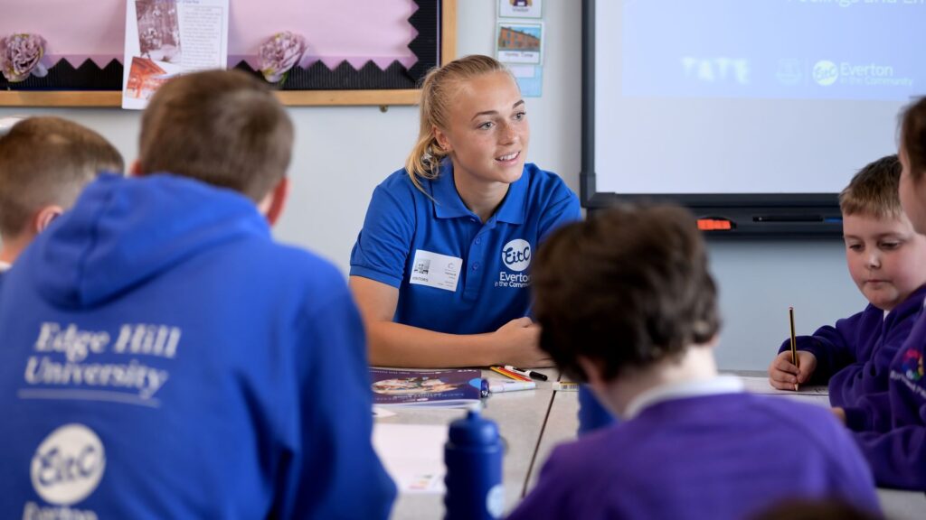 Student speaking with children in a school.