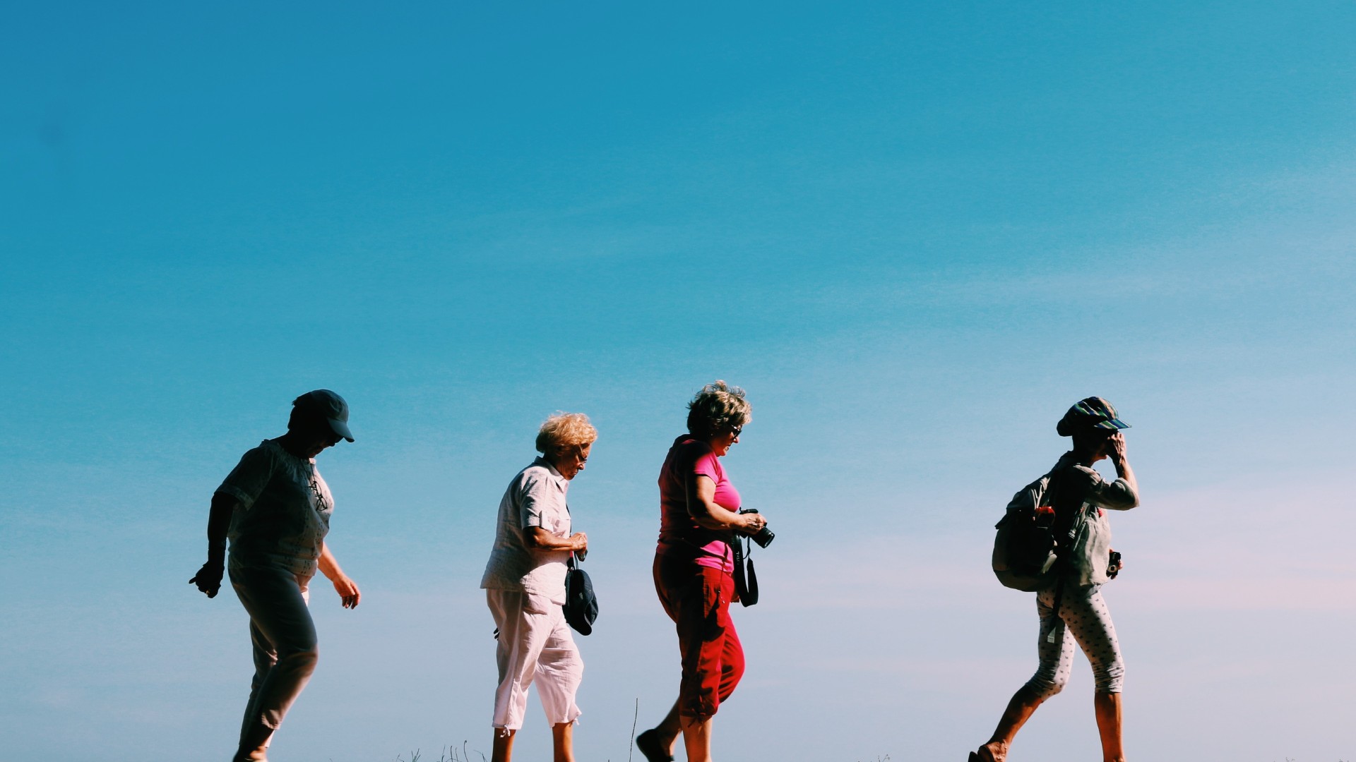 A group of four people hiking outside in a line.