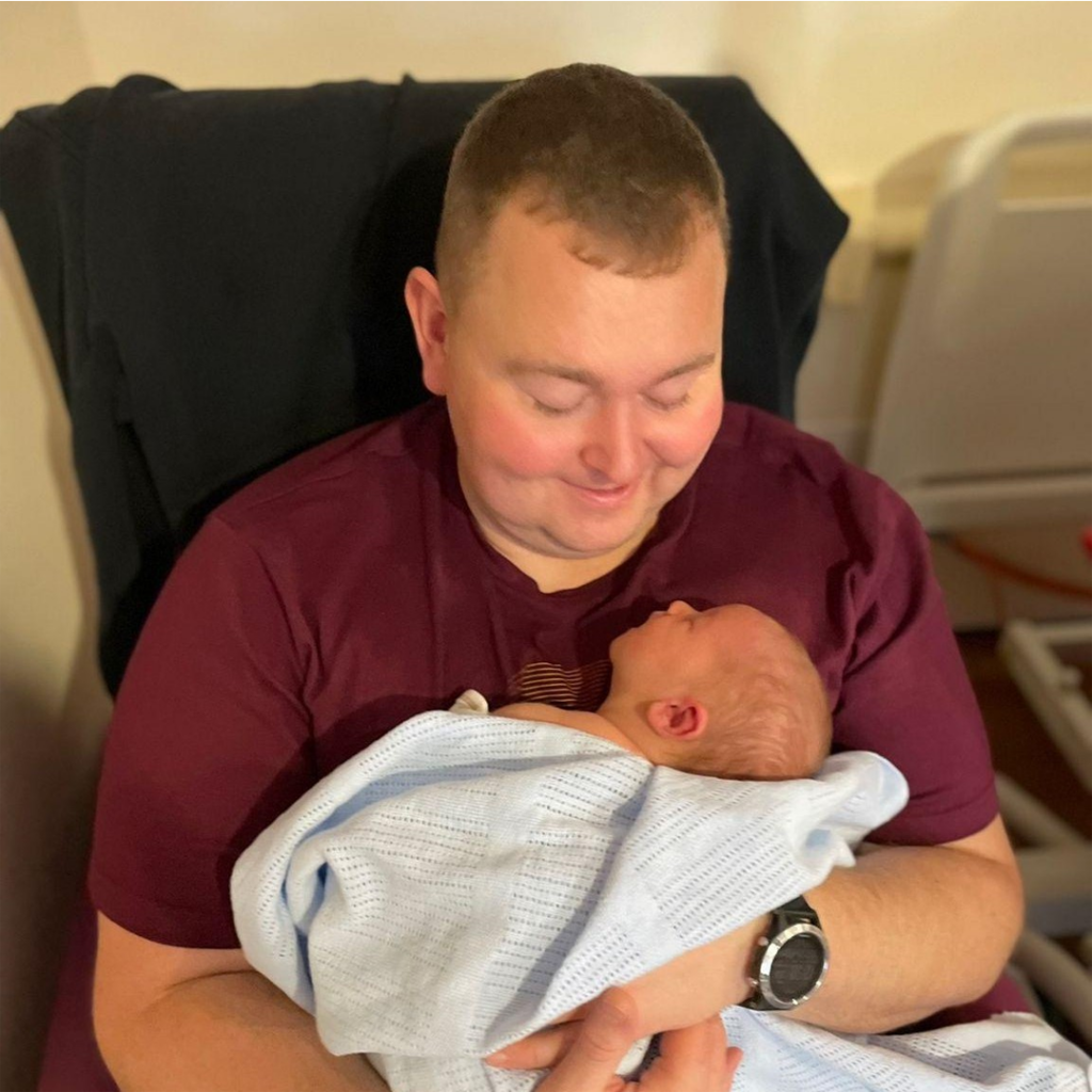 A picture of Stuart Baker holding his baby son.