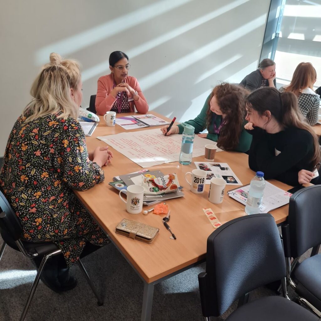 A picture of students sat around a table doing work.