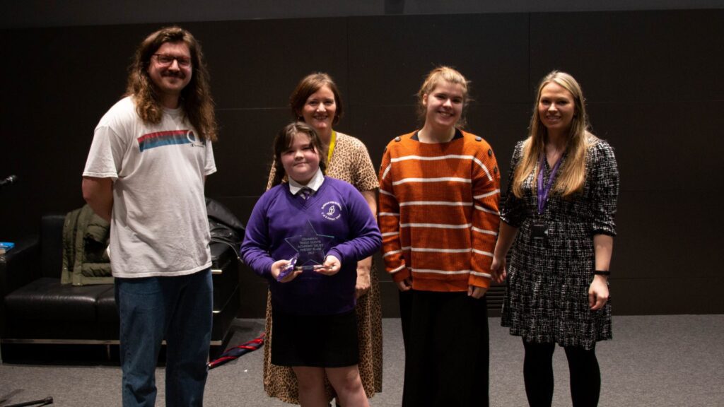 A picture of Abi holding her award.