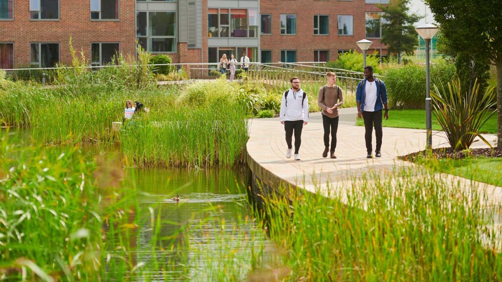 Students walking next to a lake at university