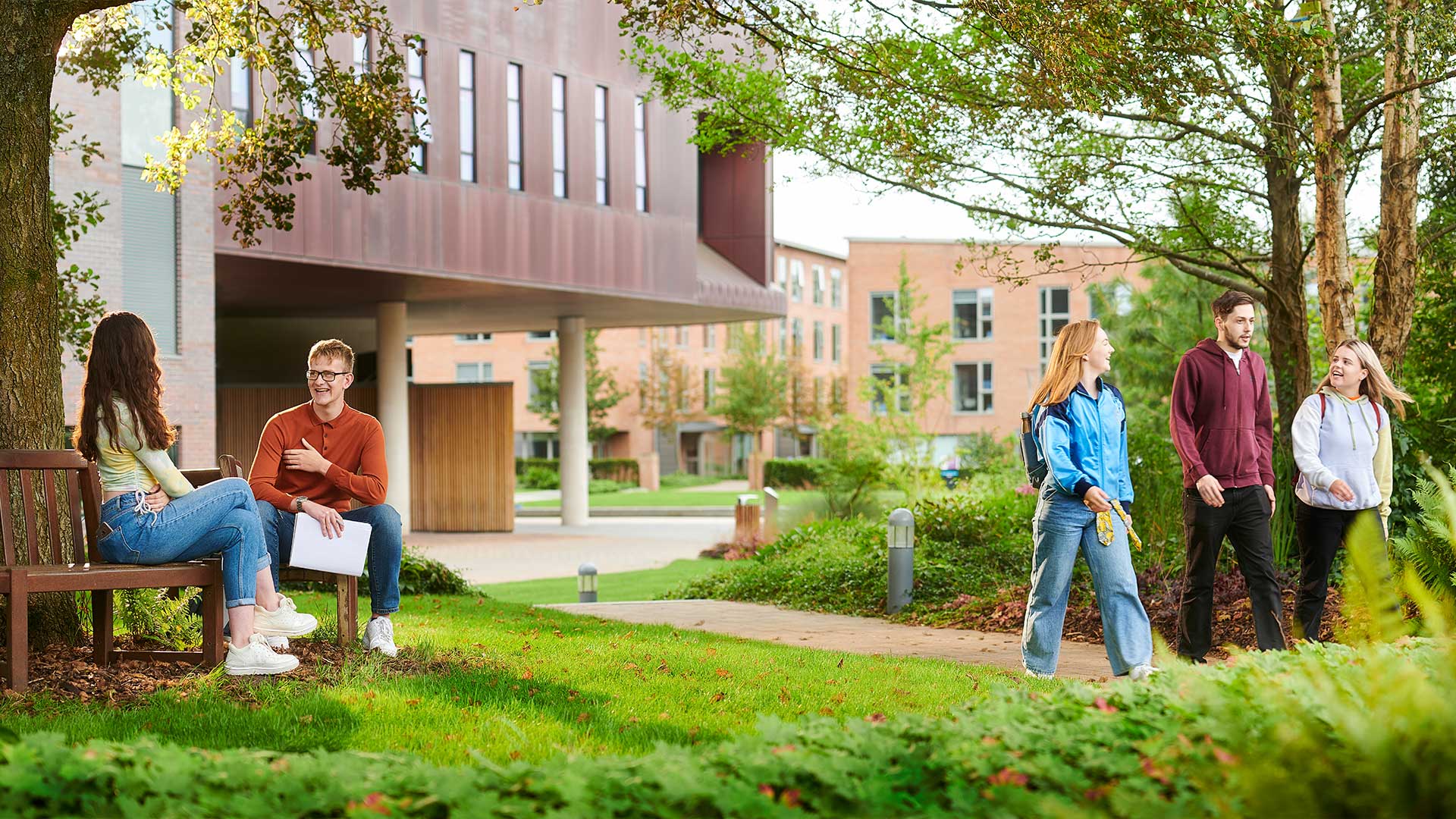 students outdoors on campus with friends