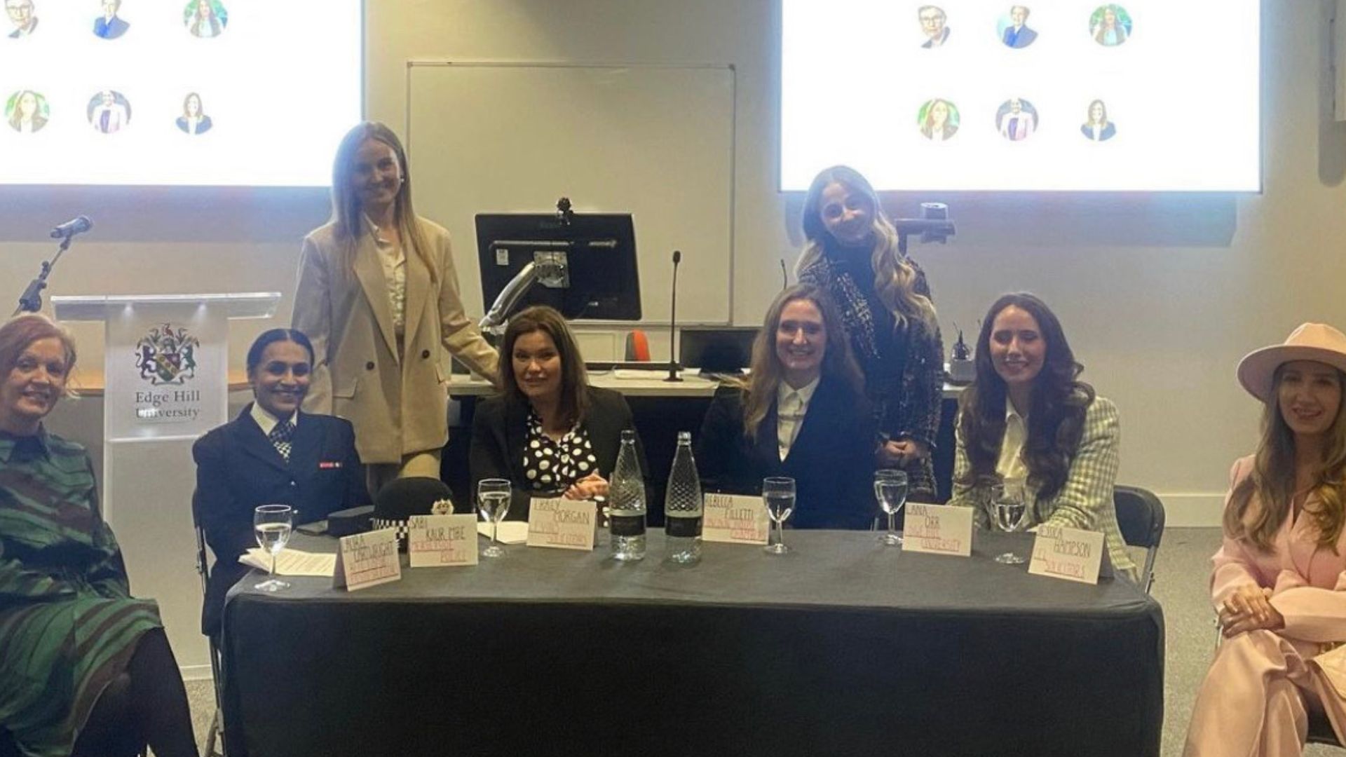 2023 International Women's Day Guest speakers sat around a table smiling towards the camera.