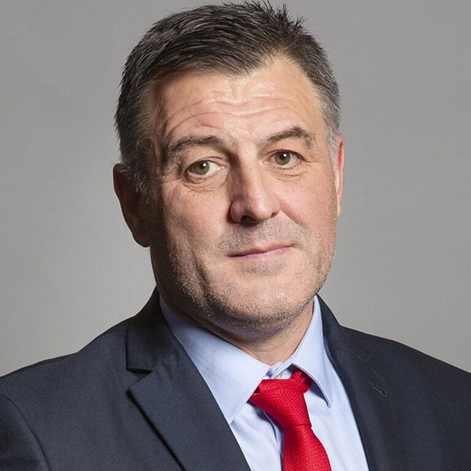 Headshot of Ian Byrne MP. He is wearing a dark suit with a light blue shirt and a red tie,