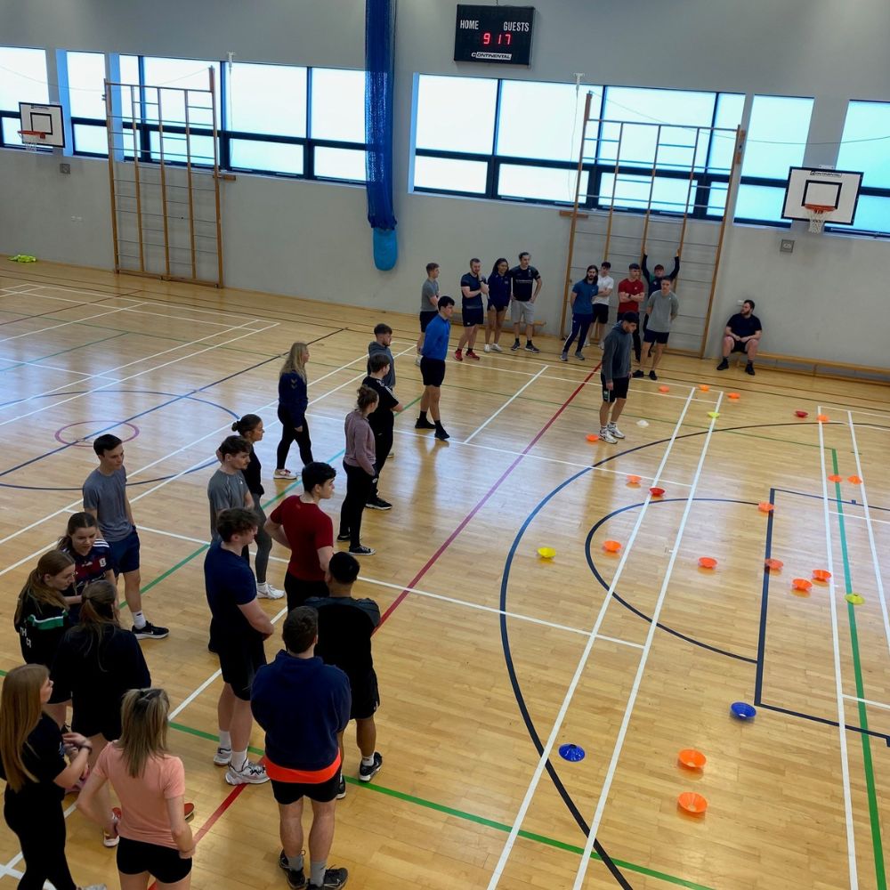 students in sports hall taking part in multi skills session