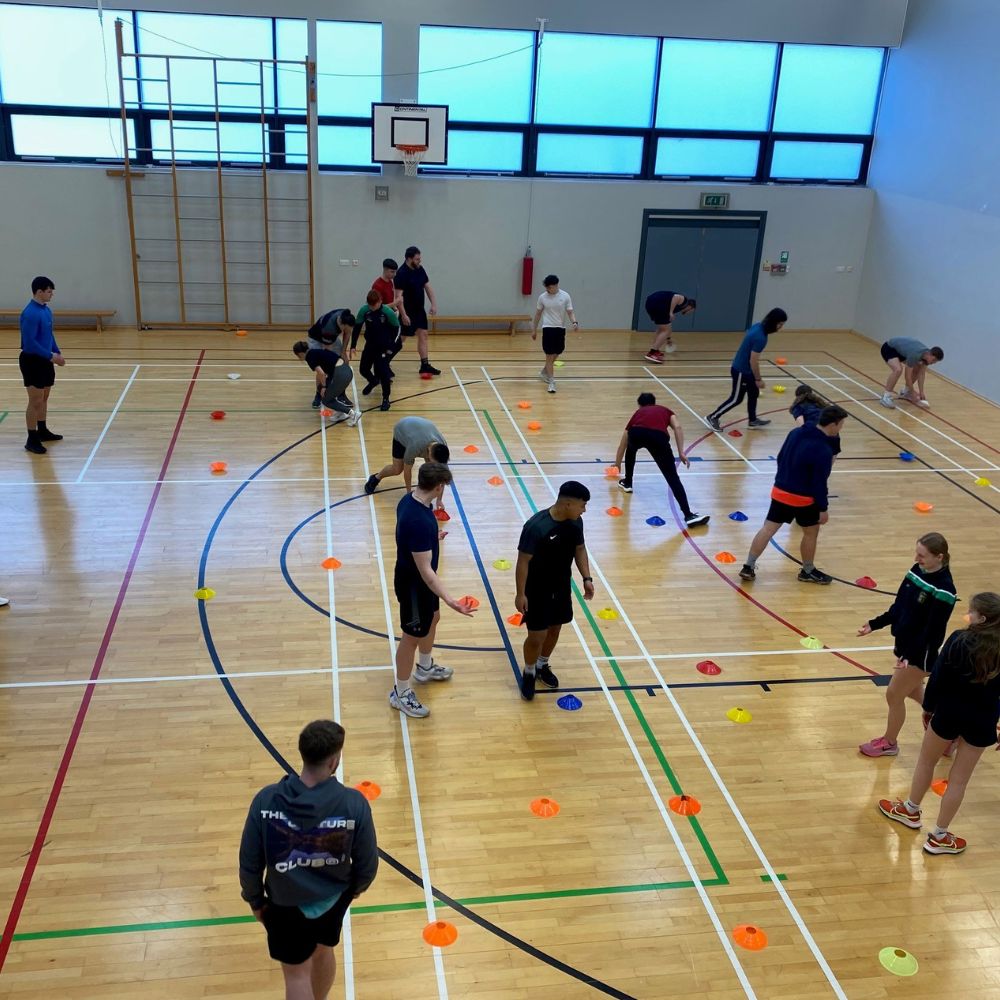 students in sports hall taking part in multi skills session