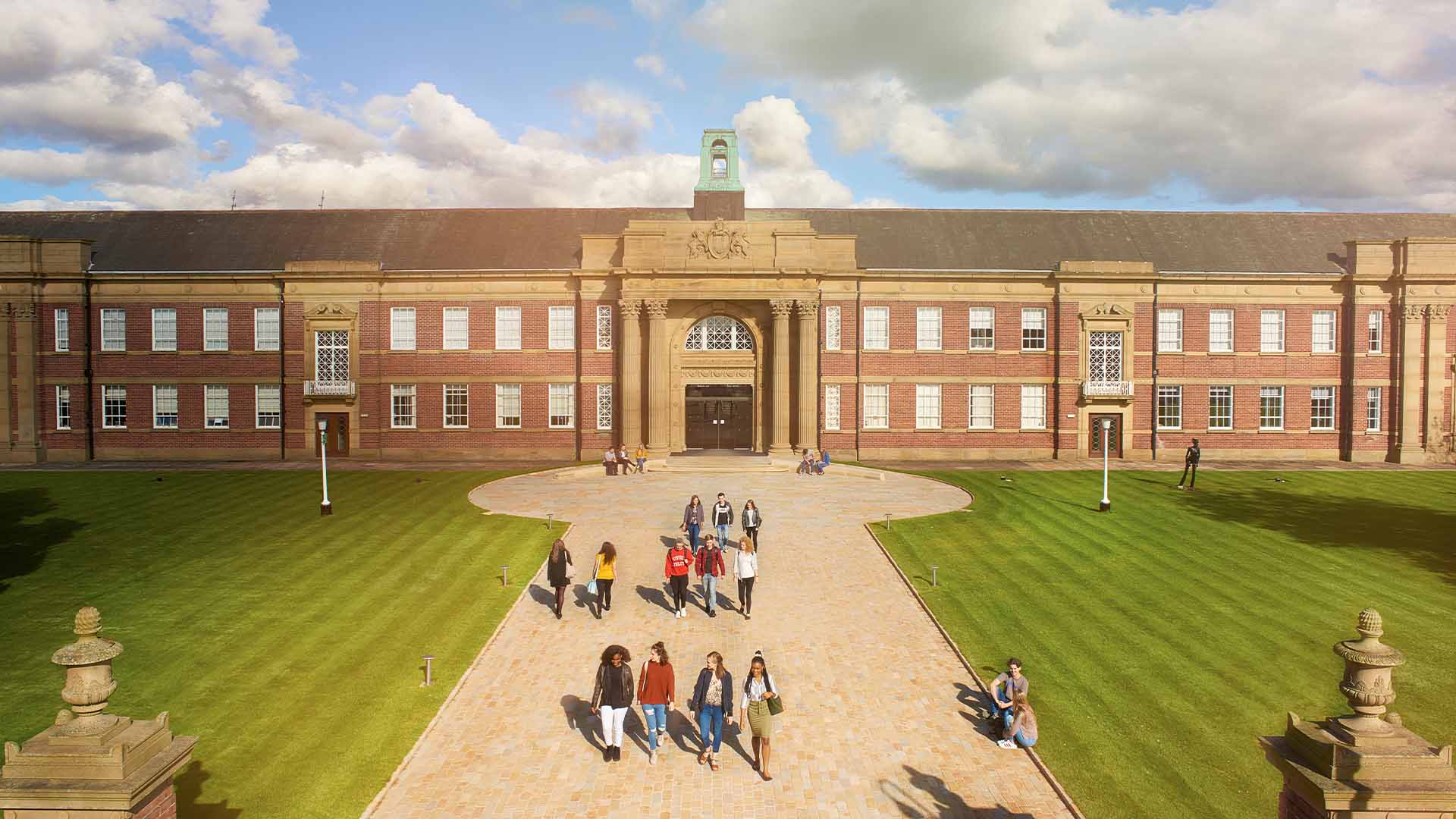 exterior shot of main building with students walking around campus