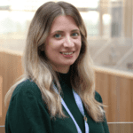 Headshot of Louise Hastings. She is wearing a green jumper and Library and Learning Services lanyard and smiling to camera.