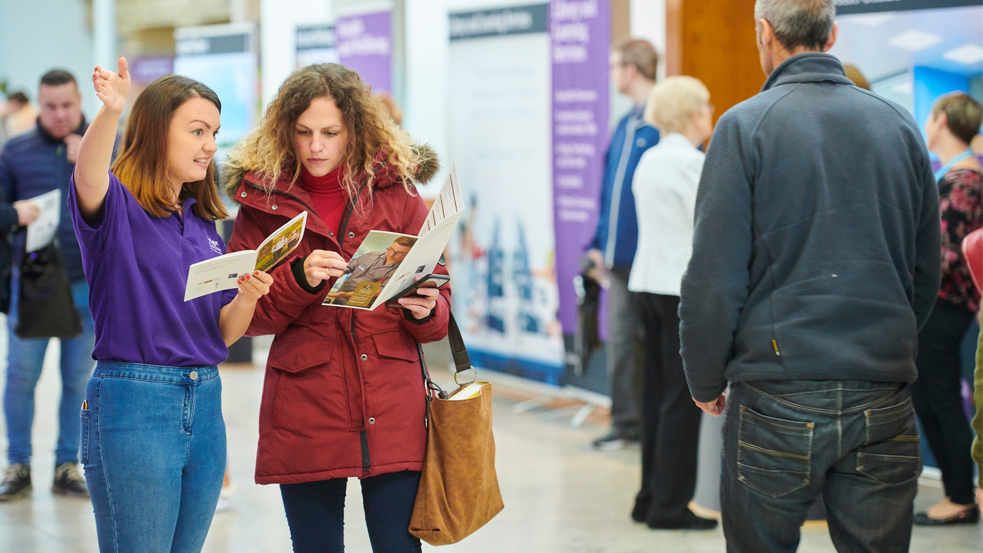 A student guide directs a mature student on an Edge Hill Open Day.
