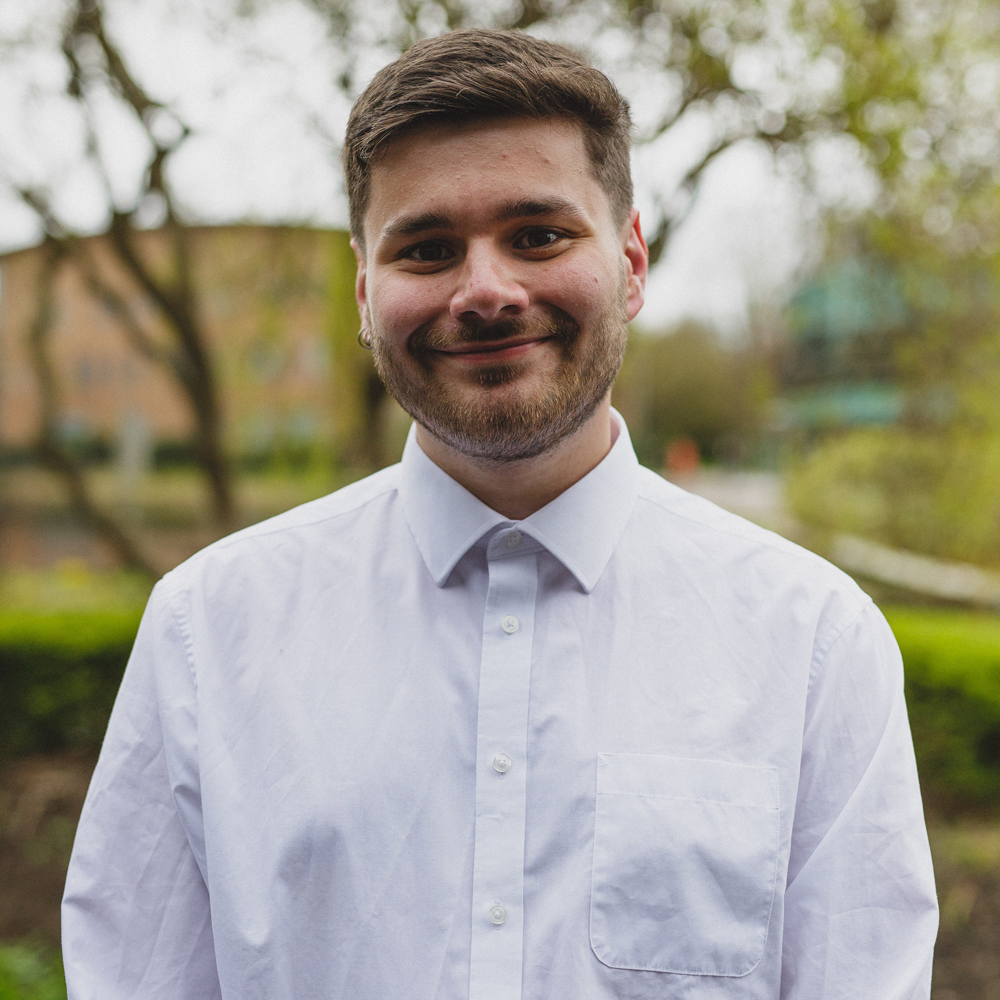 Headshot of BA (Hons) Politics and Sociology student, Thomas Jones. Student is wearing a white shirt and smiling.