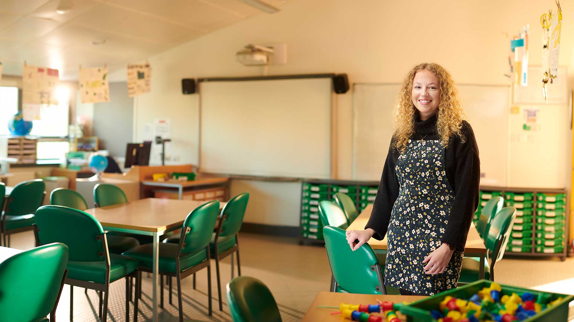 female teacher standing in empty classroom