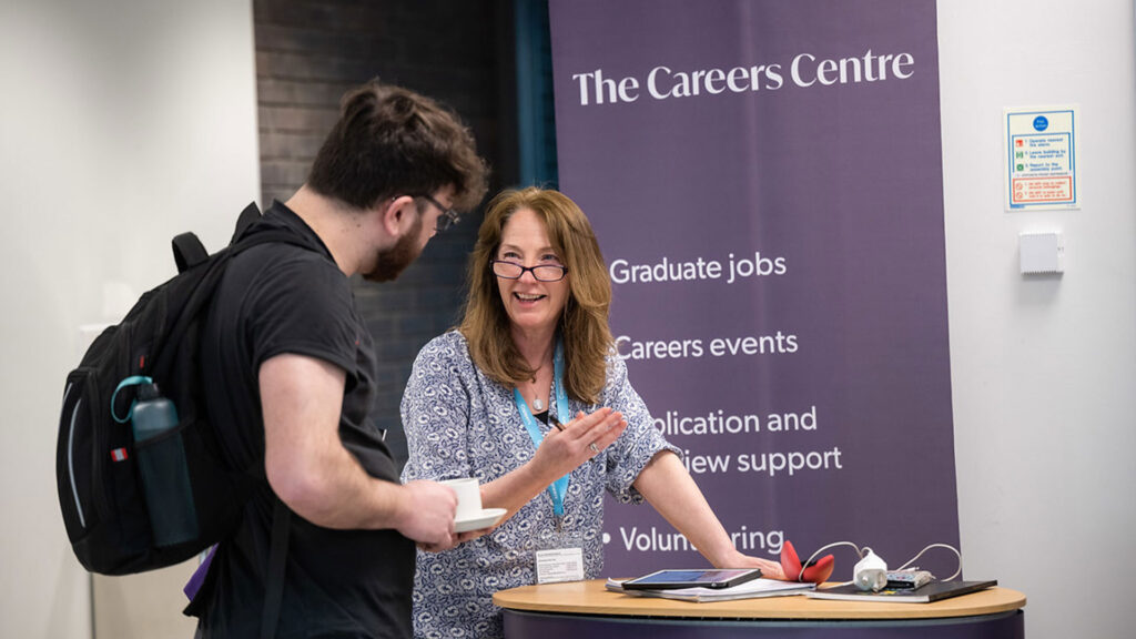 Careers Team representative talking to student at an event.