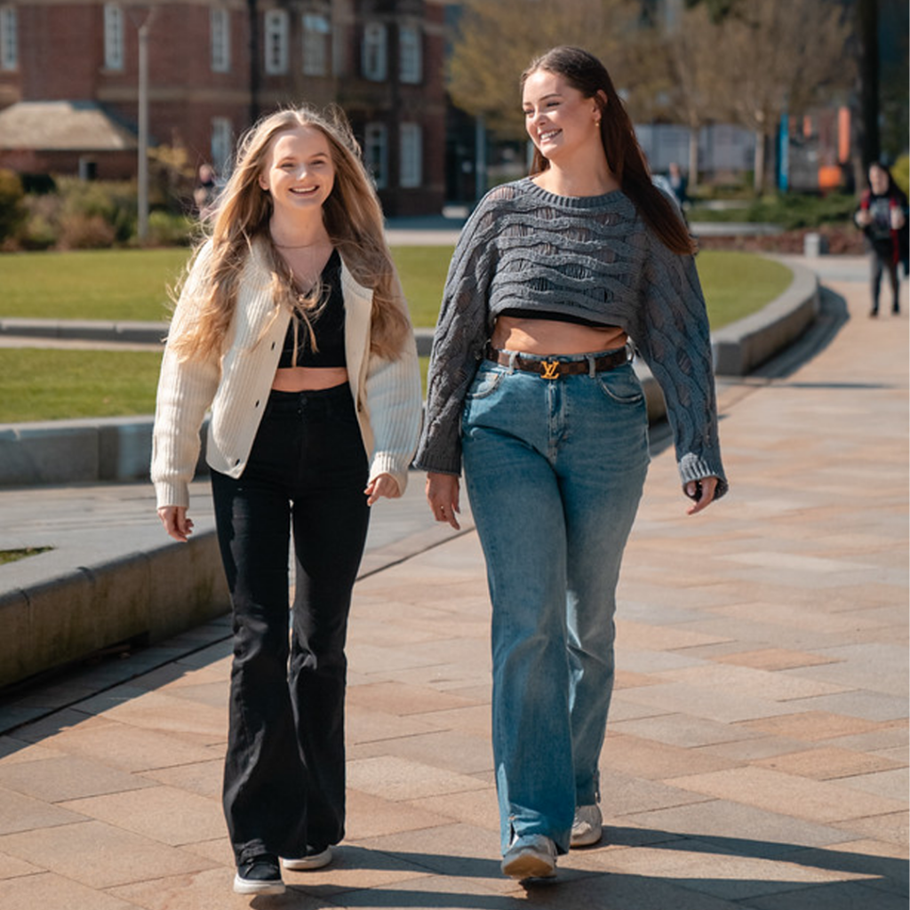 Third year students Freya and Eva chatting and laughing on campus
