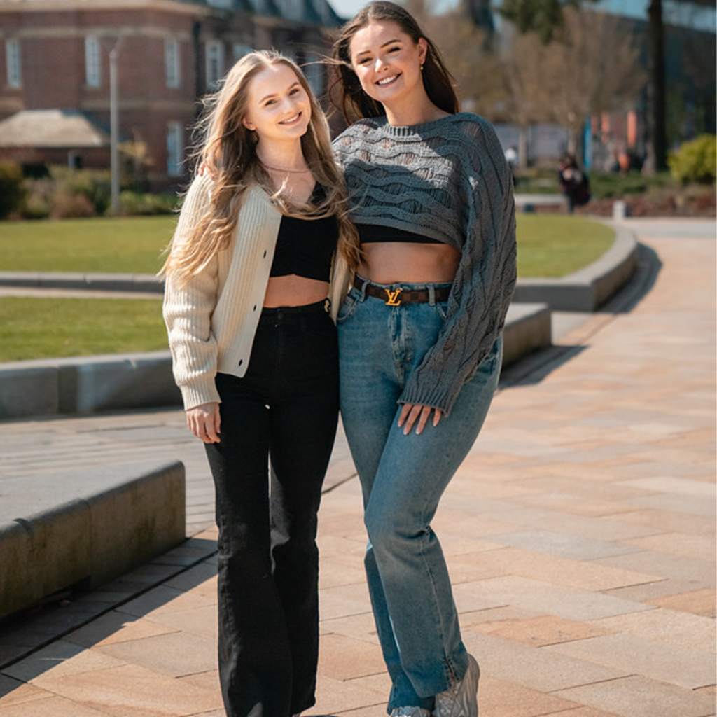 Third year students Freya and Eva smiling to camera outside Catalyst building