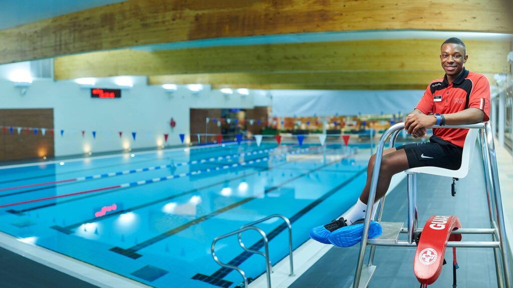 Student Rohan Williams sits at the side of the swimming pool in EHU Sport.