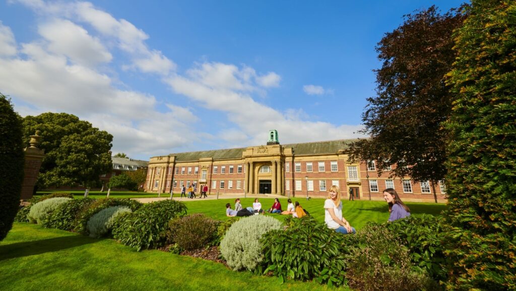 Students sitting on the lawn in front of the main building