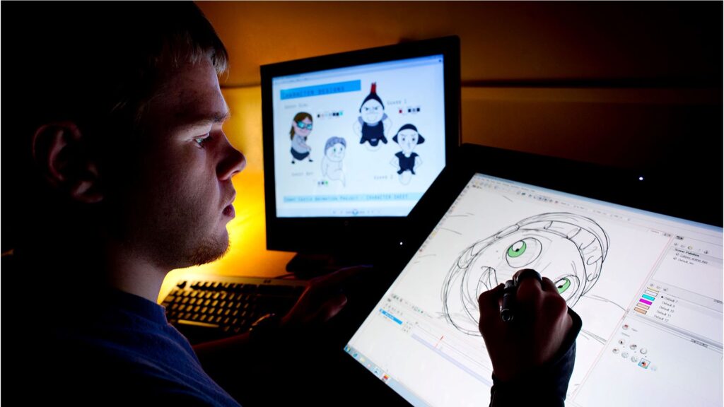 A person is drawing on a tablet. There is a computer monitor in front of them.