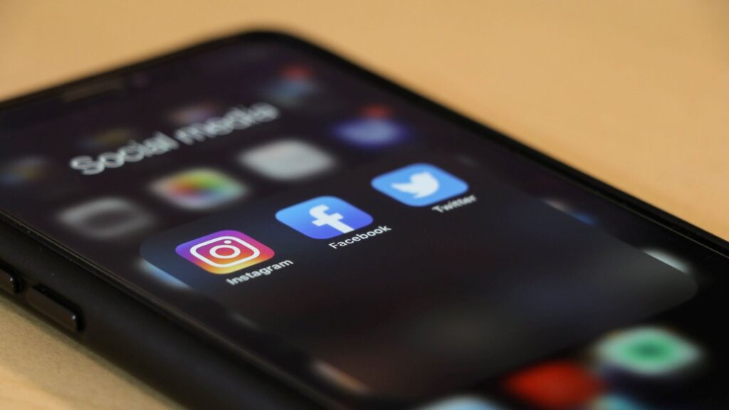 A close up of a mobile phone showing the app icons for Instagram, Facebook and Twitter