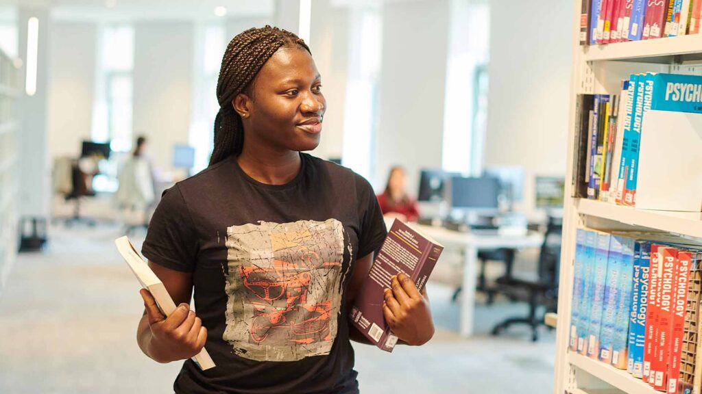 student with books in catalyst
