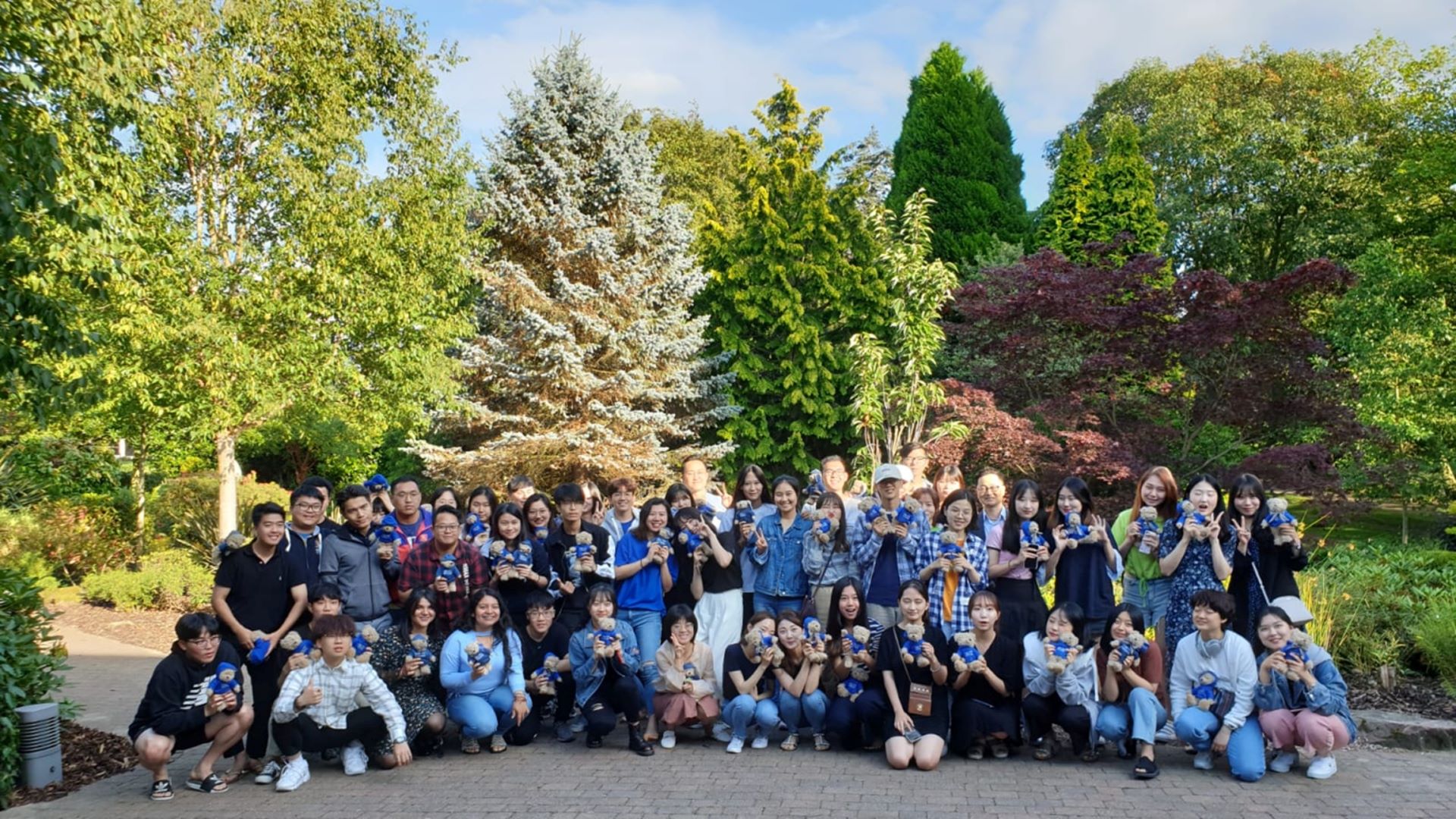 Group of international students with colourful trees in background / International
