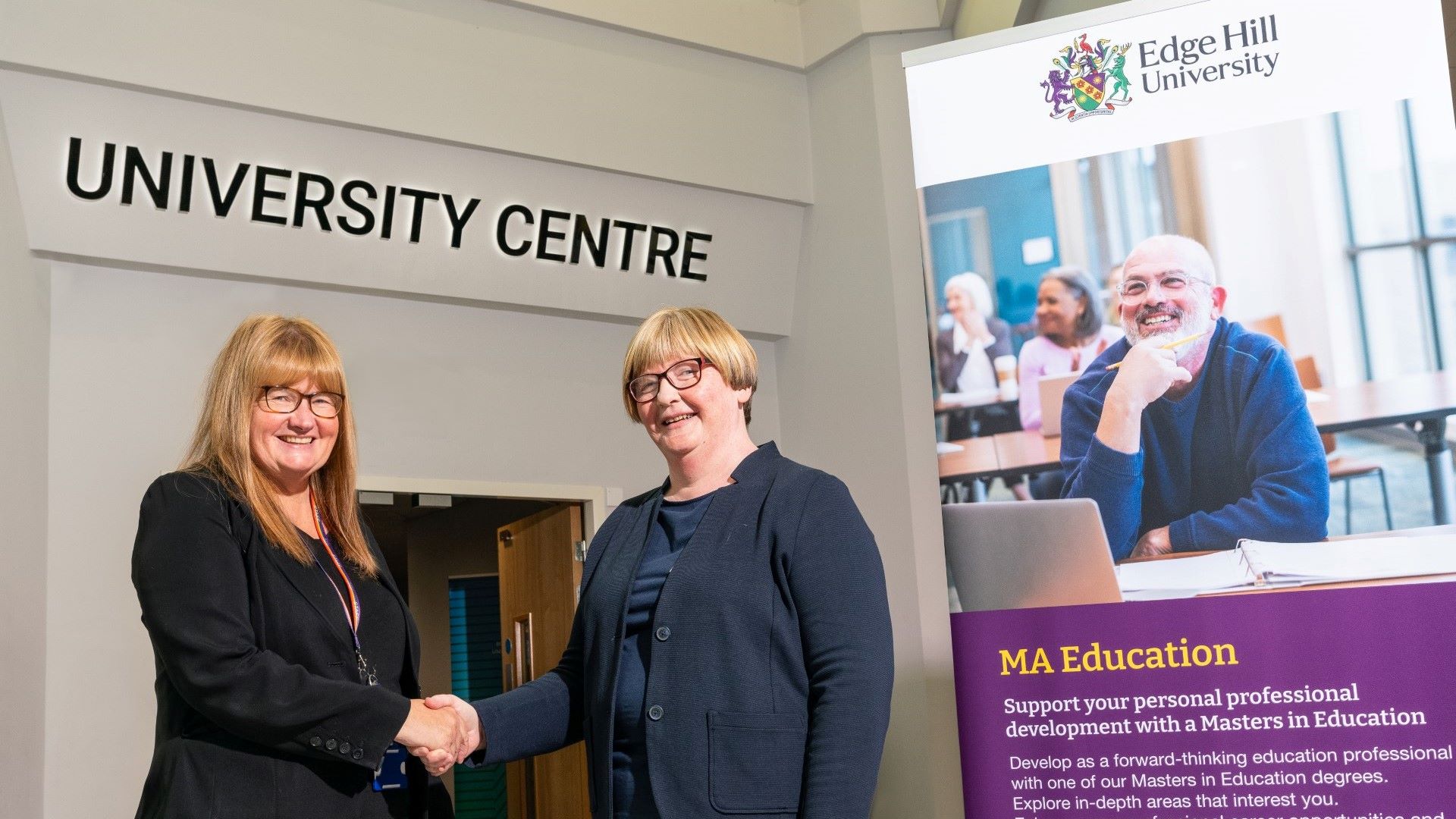 Faculty at Burnley College shaking hands outside their University Centre.