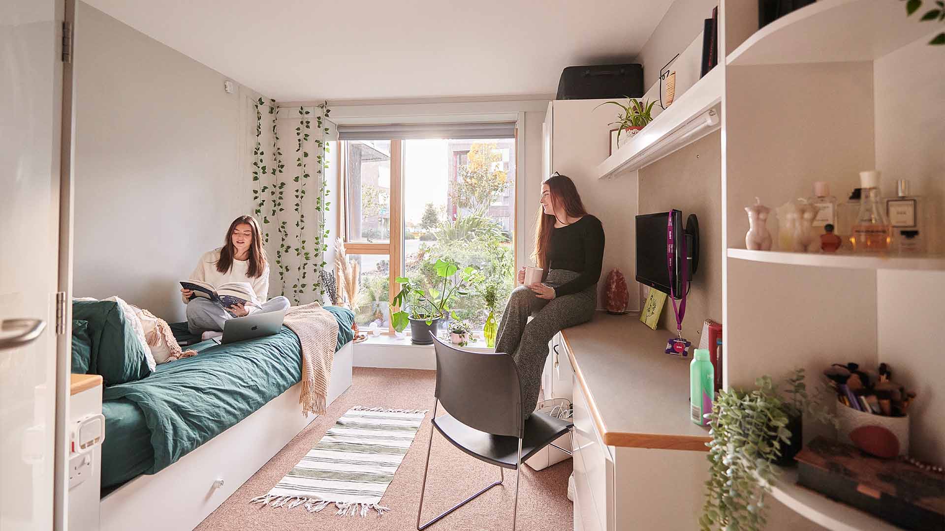 two female students sitting in halls on campus