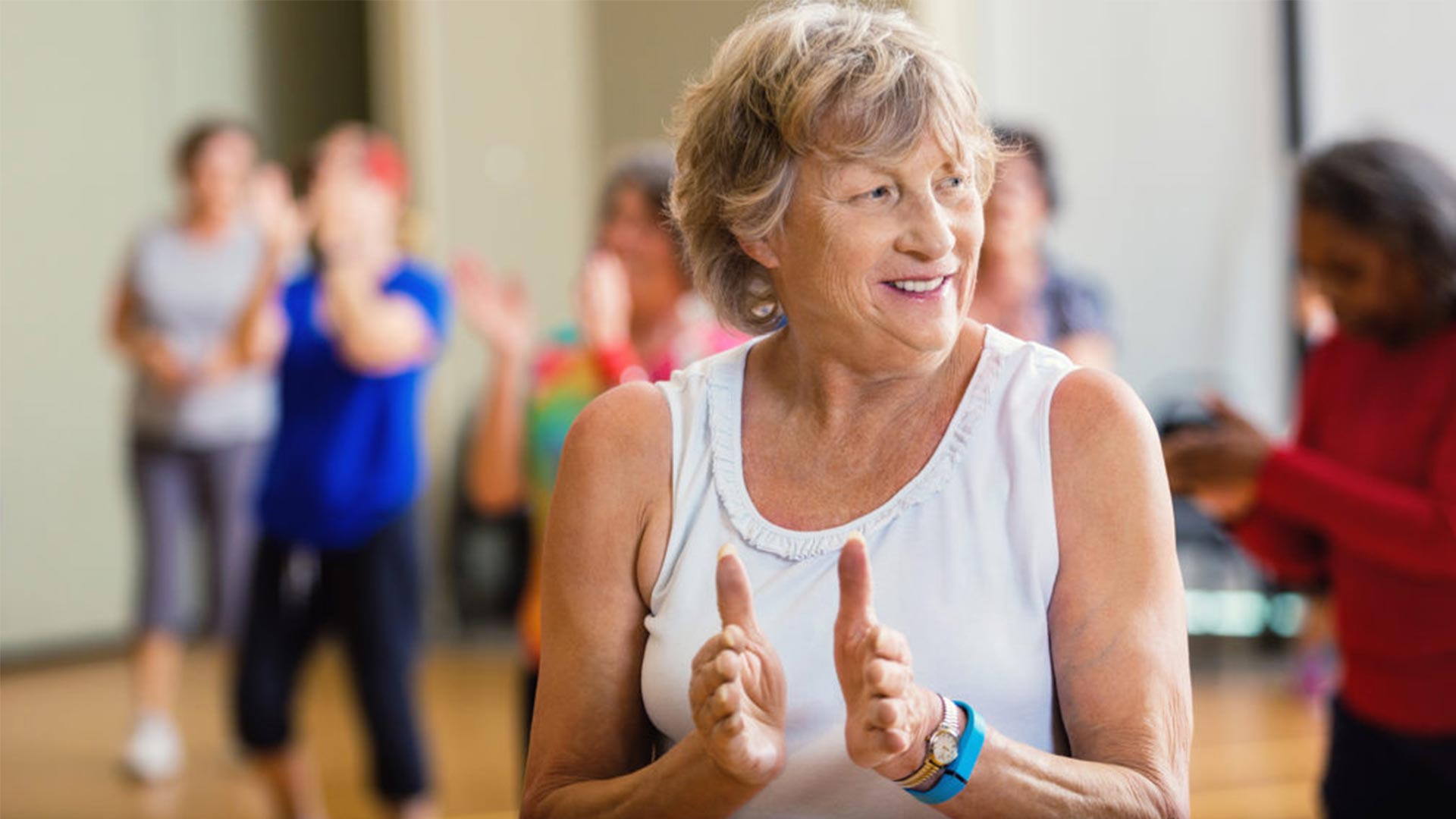 Lady claps as others behind her dance.