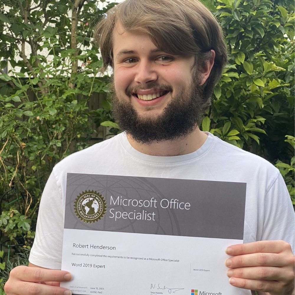 Robert Henderson posing for a photo with his Microsoft Office Specialist Certificate.